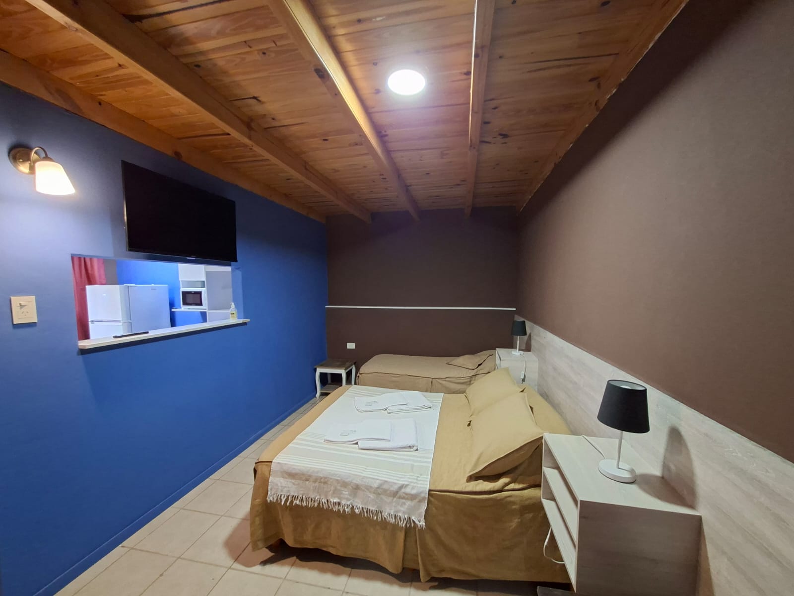Habitación Standard 4 en Hostería Marina Bella, alojamiento en Rada Tilly Chubut, con TV, camas confortables y ambiente cálido de madera.
